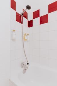 ducha con pared de azulejos rojos y blancos en Le Cocon de Lespinasse - Parking - Checkin Autonome en Lespinasse