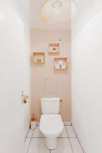 uma casa de banho com um WC branco e uma luz em Le Cocon de Lespinasse - Parking - Checkin Autonome em Lespinasse