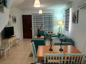 ein Wohnzimmer mit Sofa und Tisch in der Unterkunft G&E HARBOUR MAISONETTE NUMBER 13 in Lachi