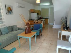 ein Wohnzimmer mit Sofa und Tisch in der Unterkunft G&E HARBOUR MAISONETTE NUMBER 13 in Lachi