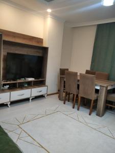 a living room with a table and chairs and a television at Moataz in Madinaty