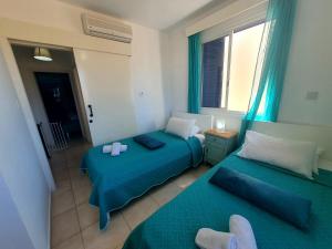 ein Hotelzimmer mit zwei Betten und einem Fenster in der Unterkunft G&E HARBOUR MAISONETTE NUMBER 13 in Lachi + 14 Fotos