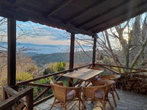 einen Holztisch und Stühle auf einer Veranda mit Aussicht in der Unterkunft Mountain and Sea view in Milies