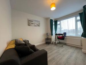 a living room with a couch and a window at The Rose Marie Lodge in Clacton-on-Sea