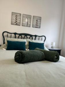a green towel laying on top of a bed at Piso Camino de Santiago in Sarria