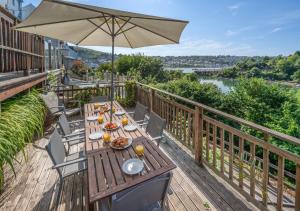 a wooden deck with a table and an umbrella at Genista in Dartmouth