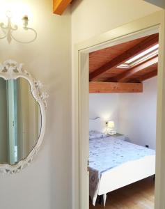 - une chambre avec un lit et un miroir dans l'établissement La Maison di Bologna, à Bologne