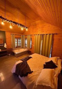 een slaapkamer met een groot bed en een bad bij Aka Fishing Lodge in Guarapuava
