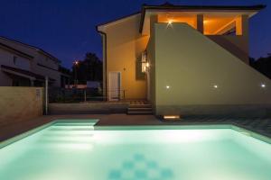 uma piscina em frente a uma casa à noite em Ferienhaus für 20 Personen in Banjole, Istrien Istrische Riviera - b55564 em Banjole