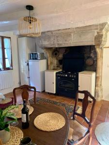 a living room with a table and a stove at La Lotoise gîte au Coeur De Saint-Cirq-Lapopie in Saint-Cirq-Lapopie