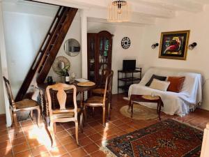 - une chambre avec un lit, une table et des chaises dans l'établissement La Lotoise gîte au Coeur De Saint-Cirq-Lapopie, à Saint-Cirq-Lapopie