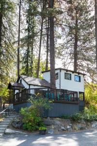 a house with a wrap around deck in the woods at LOGE Leavenworth Riverside in Leavenworth