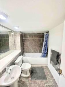 a bathroom with a toilet and a tub and a sink at LUXstay 2BR Earls Court Apartment Sleeps up to 10 in London