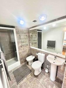 ein Bad mit einem WC, einem Waschbecken und einer Dusche in der Unterkunft LUXstay 2BR Earls Court Apartment Sleeps up to 10 in London