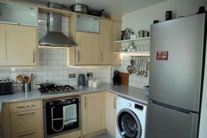 eine Küche mit einem Kühlschrank und einer Waschmaschine in der Unterkunft In Our Liverpool Home Sleeps 5 in 2 Double & 1 Single Bedrooms in Liverpool