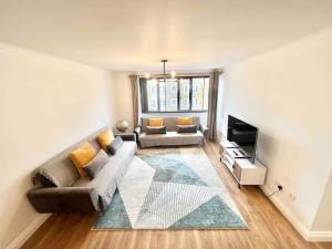 a living room with a couch and a television at LUXstay 2BR Earls Court Apartment Sleeps up to 10 in London