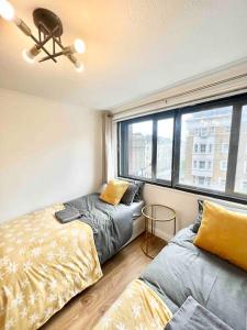 1 Schlafzimmer mit 2 Betten und einem Fenster in der Unterkunft LUXstay 2BR Earls Court Apartment Sleeps up to 10 in London