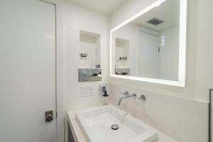 a white bathroom with a sink and a mirror at Village Camp in Truckee