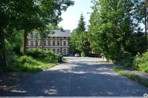 an empty road in front of a large building at Apartament FANABERIA Lądek Zdrój in Lądek-Zdrój