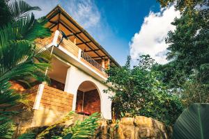 a house with a balcony on the side of it at Huingos Eco Lodge in Tarapoto