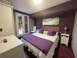 una camera da letto con un grande letto con pareti viola di Ferienhaus für 4 Personen und 2 Kinder in Urb La Suerte, Gran Canaria Westküste Gran Canaria ad Agaete