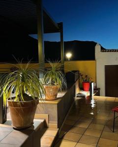 dois vasos de plantas sentados numa varanda à noite em Ferienhaus für 4 Personen und 2 Kinder in Urb La Suerte, Gran Canaria Westküste Gran Canaria em Agaete
