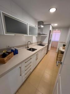 eine Küche mit weißen Schränken und einem Waschbecken in der Unterkunft Apartamento Jardín de Atalaya in Camas