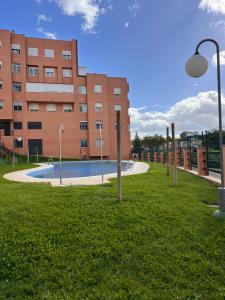 ein Gebäude mit einem Pool vor einem Gebäude in der Unterkunft Apartamento Jardín de Atalaya in Camas