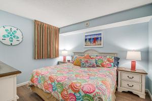 1 dormitorio con 1 cama y 2 mesitas de noche con lámparas en Beachy Condo with Pool Access and Steps to Boardwalk!, en Myrtle Beach