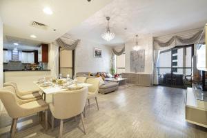 a dining room and living room with a table and chairs at Stylish and Sleek: Modern Well-Furnished One Bedroom Hall and Kitchen Apartment in Dubai