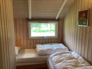 Cette chambre comprend 2 lits et une fenêtre. dans l'établissement Holiday home Ansager XLI, à Ansager