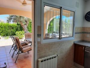 a kitchen with a patio with chairs and a window at Casa Angela, Gata de Gorgos with heated pool in Gata de Gorgos