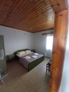 a bedroom with a bed and a wooden ceiling at Villa Savvas in Paralia Vrachou