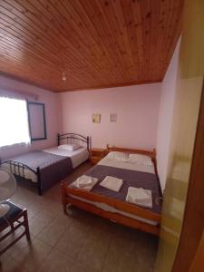 a bedroom with two beds and a wooden ceiling at Villa Savvas in Paralia Vrachou