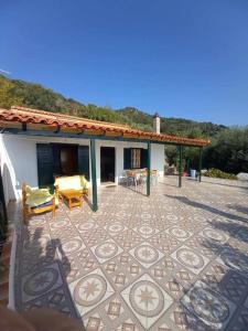 a house with a patio with a table and chairs at Villa Savvas in Paralia Vrachou