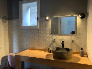 MormoironにあるMaison de Vacances La Commanderieのバスルーム(石造りの洗面台、鏡付)