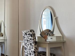 una habitación con una silla y un espejo en una mesa en Avecilla VUT-LE-868 Inmueble singular en el centro de León by ARoom, en León