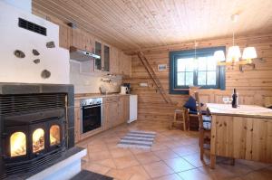 a kitchen with a fireplace in a log cabin at Charmantes modernes Blockhaus mit Kamin in Galåbodarna