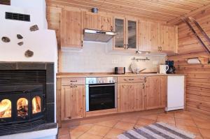 a kitchen with wooden cabinets and a stove at Charmantes modernes Blockhaus mit Kamin in Galåbodarna