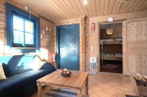 uma sala de estar com um sofá azul e uma mesa em Charmantes modernes Blockhaus mit Kamin em Galåbodarna