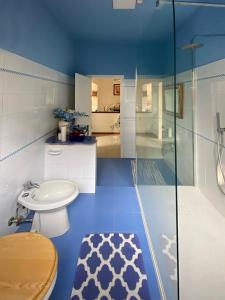 een blauwe badkamer met een toilet en een wastafel bij Casa Serena in Induno Olona