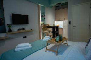 a room with a bed with a table and a television at Pocket House - Κοζανη in Kozani
