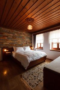 sypialnia z dużym łóżkiem i drewnianym sufitem w obiekcie Hotel Pashai w Gjirokastrze