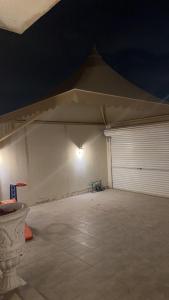 Haiat Villa في الرياض: خيمة بيضاء كبيرة مع باب وكراج