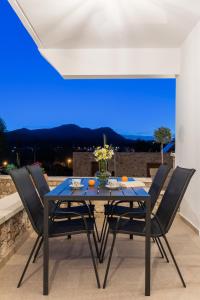 una mesa de comedor con sillas y una luz azul en Casa Arches, Rhodes en Archipolis