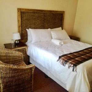 - une chambre avec un lit et une chaise dans l'établissement Letloepe Lodge, à Qachaʼs Nek