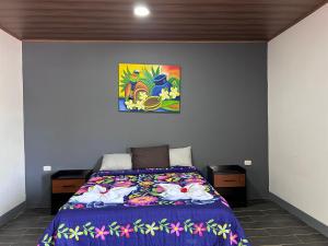 モヨガルパにあるHostal Mamá Derlysのベッドルーム1室(ベッド1台付)が備わります。壁には絵画が飾られています。