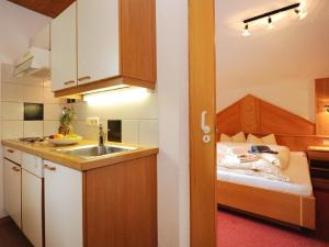 a small kitchen with a sink and a bed at Ferienwohnung in Galtür mit Kleiner Terrasse in Galtür