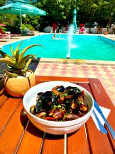 un tazón de comida en una mesa junto a una piscina en Edmond, en Eforie Sud