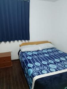 a bedroom with a bed with a blue comforter at Black Sheep Hostel Cusco in Cusco